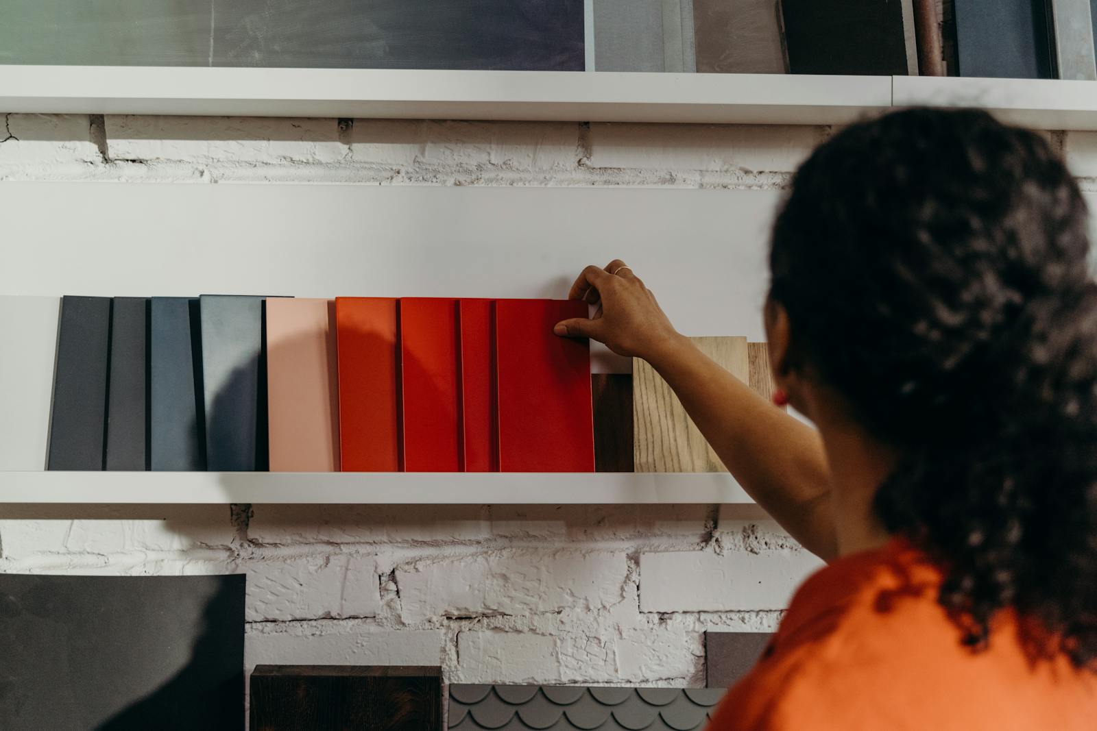 A woman chooses from an array of color samples in a design showroom.
